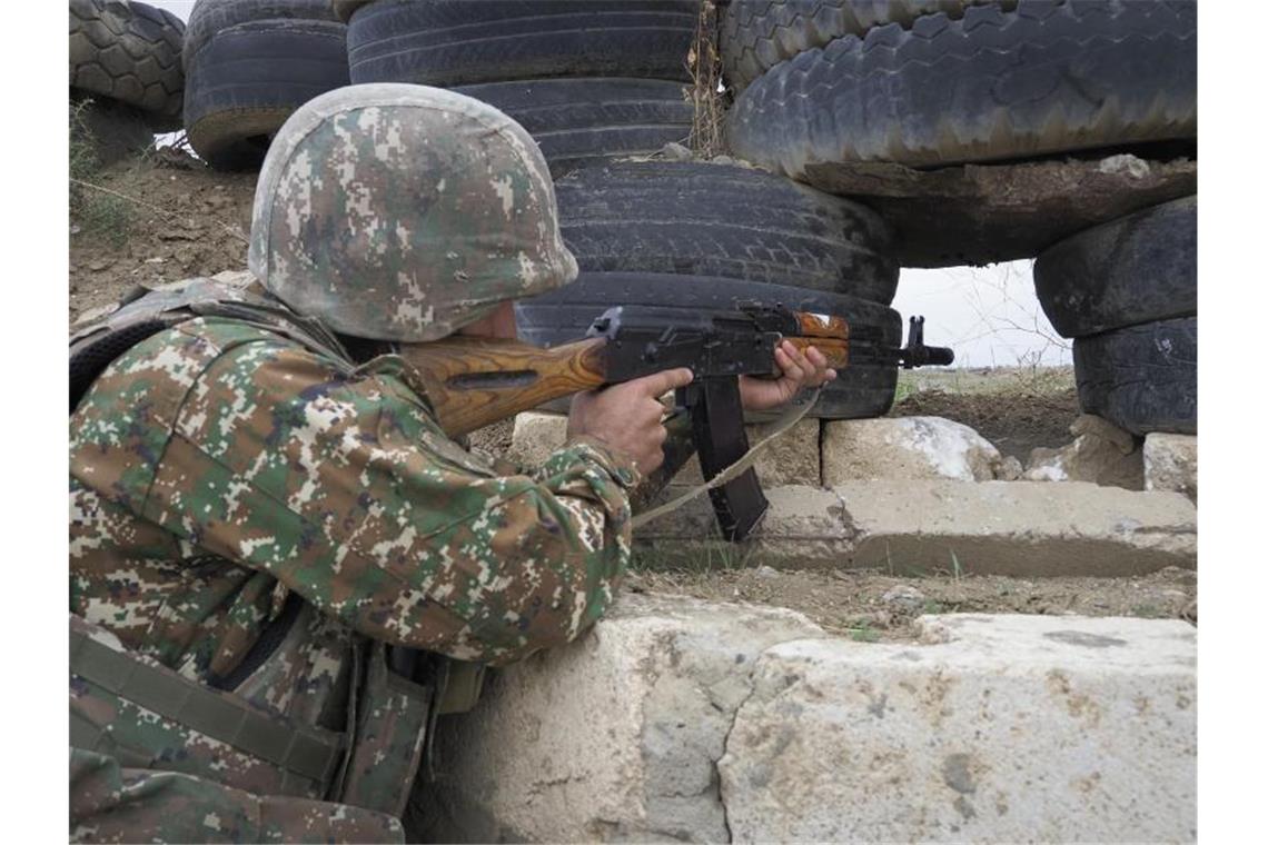 Ein armenischer Soldat zielt in Richtung der aserbaidschanischen Stellungen. Foto: -/AP/dpa