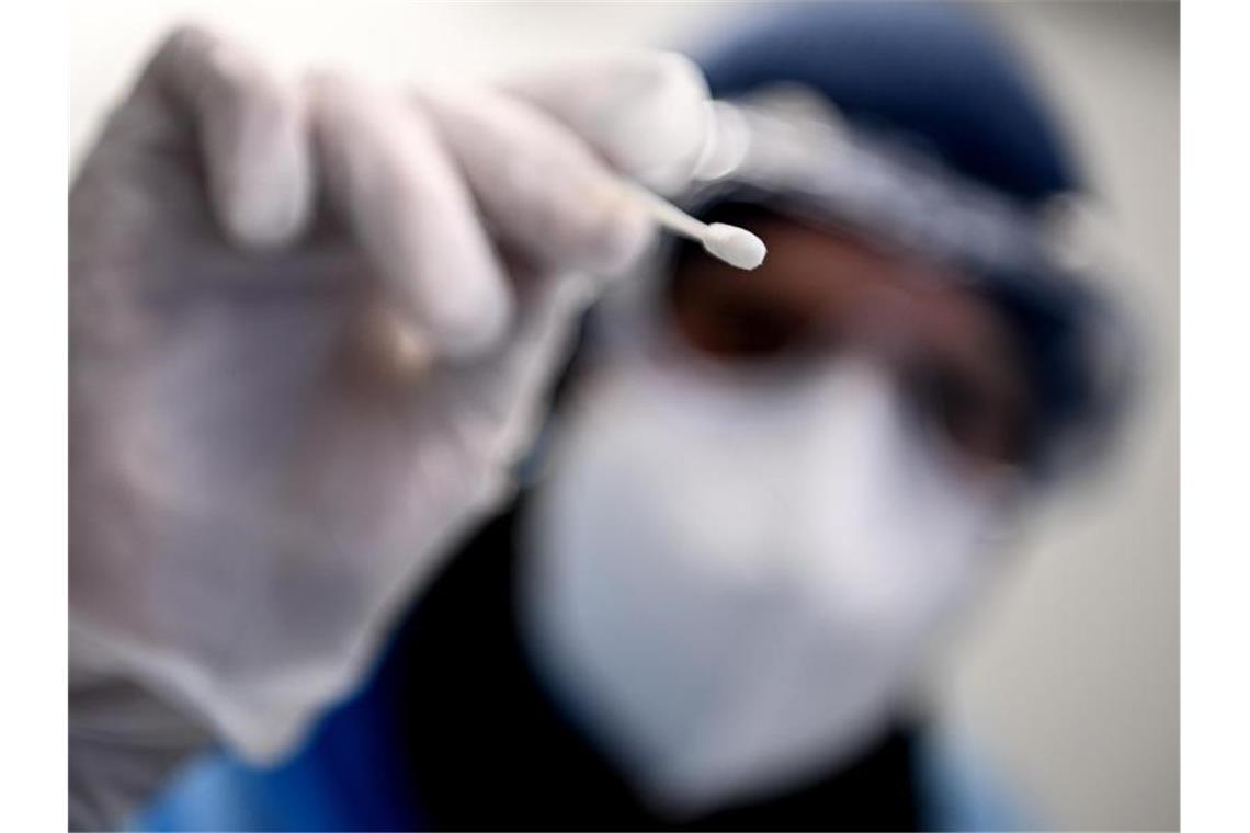 Corona-Inzidenz mit Jojo-Effekt: Sinkt nach Anstieg wieder Ein Arzt hält ein Teststäbchen für die Entnahme einer Probe für einen Corona-Test in der Hand. Foto: Britta Pedersen/dpa-Zentralbild/dpa/Symbolbild