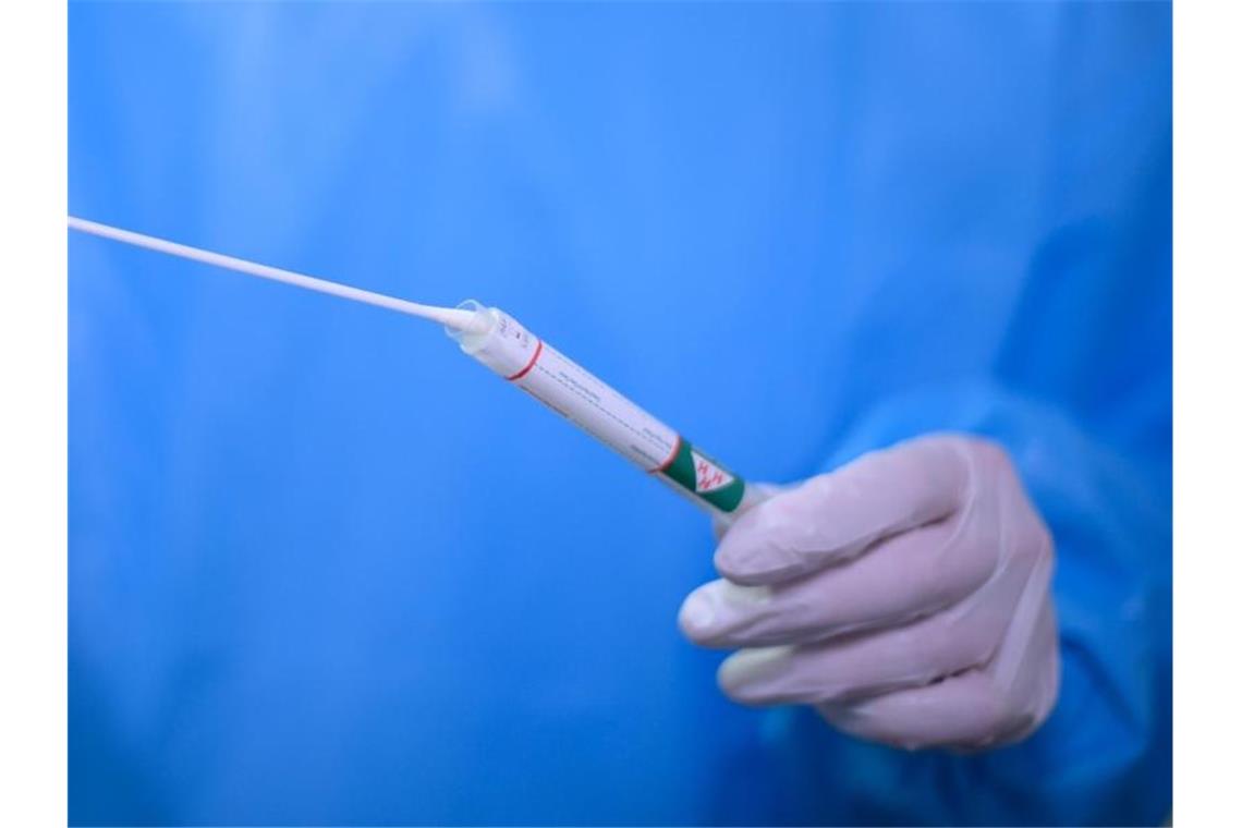 Besucher von Club in Ravensburg positiv auf Corona getestet Ein Arzt hält einen Coronavirus-Test in den Händen. Foto: Robert Michael/dpa-Zentralbild/dpa/Symbolbild