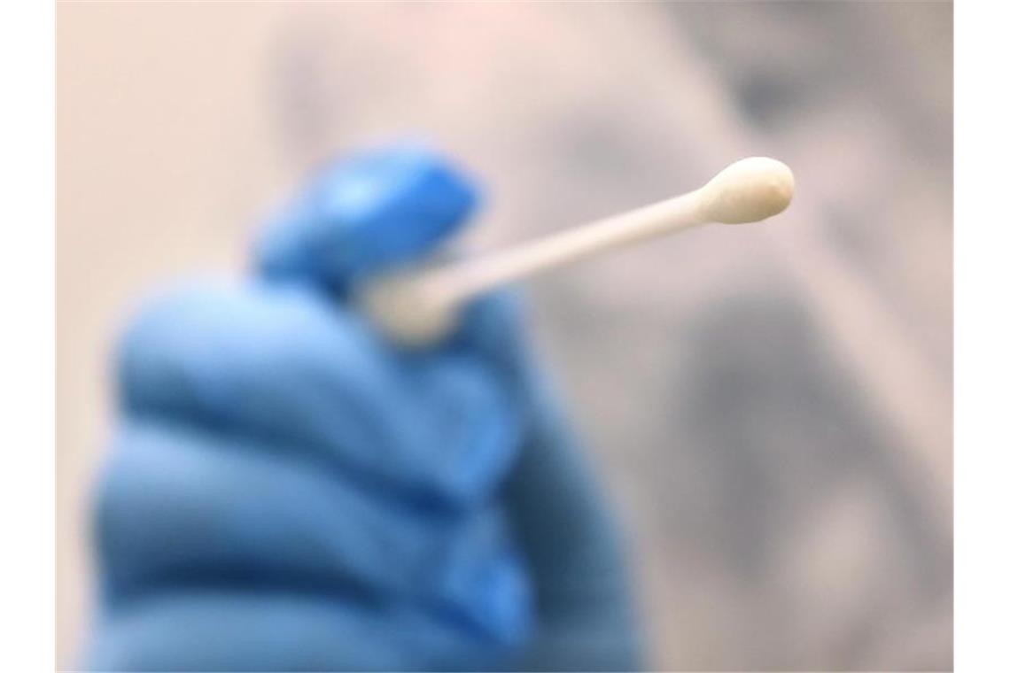 Corona-Ansteckungen erstmals über der Zwei-Millionen-Marke Ein Arzt hält einen Tupfer, mit dem ein Abstrich für einen Coronatest gemacht wird. Foto: Karl-Josef Hildenbrand/dpa/Symbolbild