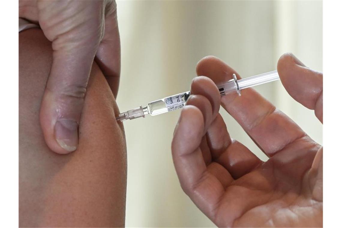 Corona und Grippe: Hausärzte für zwei Impfungen am Termin Ein Arzt impft eine Patientin gegen Grippe. Foto: Jens Kalaene/dpa-Zentralbild/dpa
