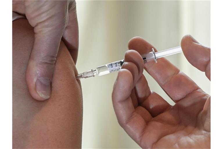 Ein Arzt impft eine Patientin gegen Grippe. Foto: Jens Kalaene/dpa-Zentralbild/dpa