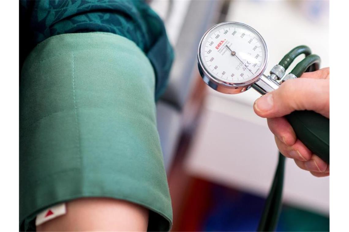 Ein Arzt misst den Blutdruck einer Patientin. Foto: Hauke-Christian Dittrich/dpa/Symbolbild