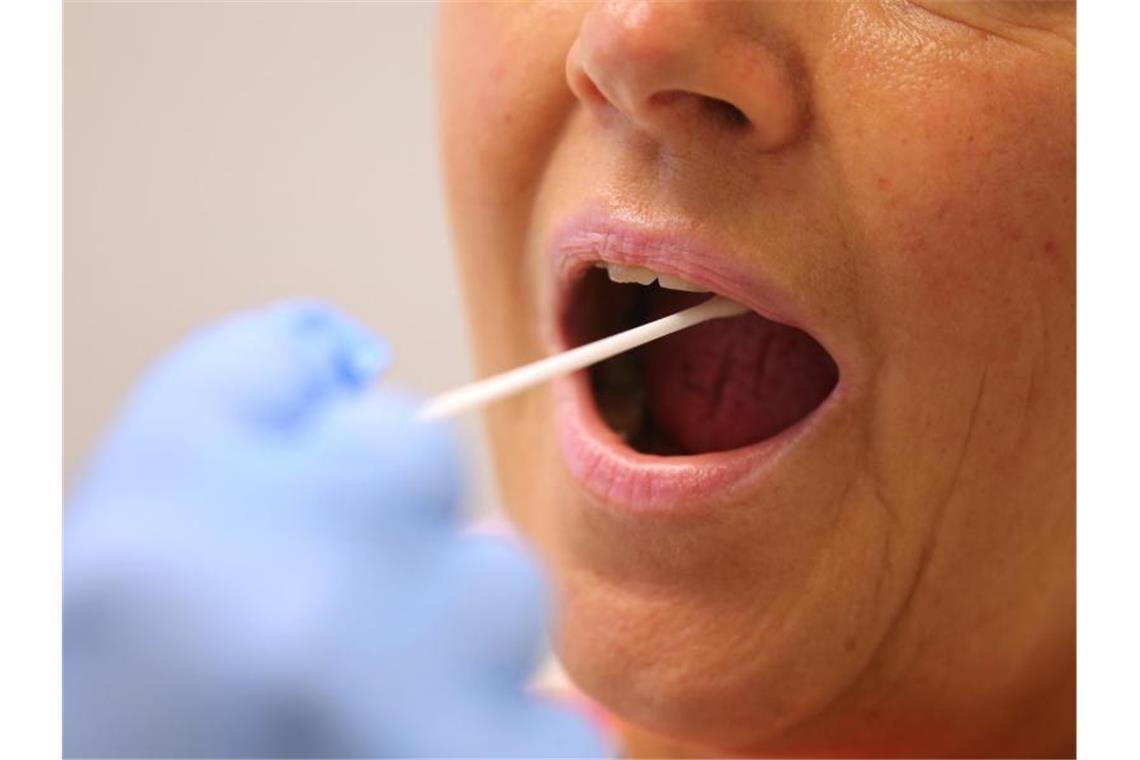 Corona-Ausbruch in mehreren Kliniken im Südwesten Ein Arzt nimmt in einer Hausarztpraxis mit einem Tupfer einen Abstrich bei einer Frau für einen Coronatest. Foto: Karl-Josef Hildenbrand/dpa/archiv