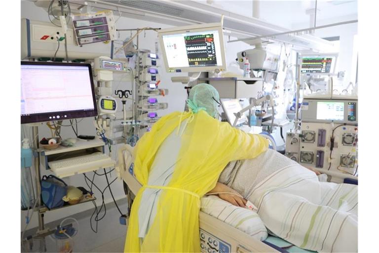 Ein Arzt untersucht einen Patienten auf einer Covid 19 Intensivstation. Foto: Bodo Schackow/dpa-zentralbild/dpa