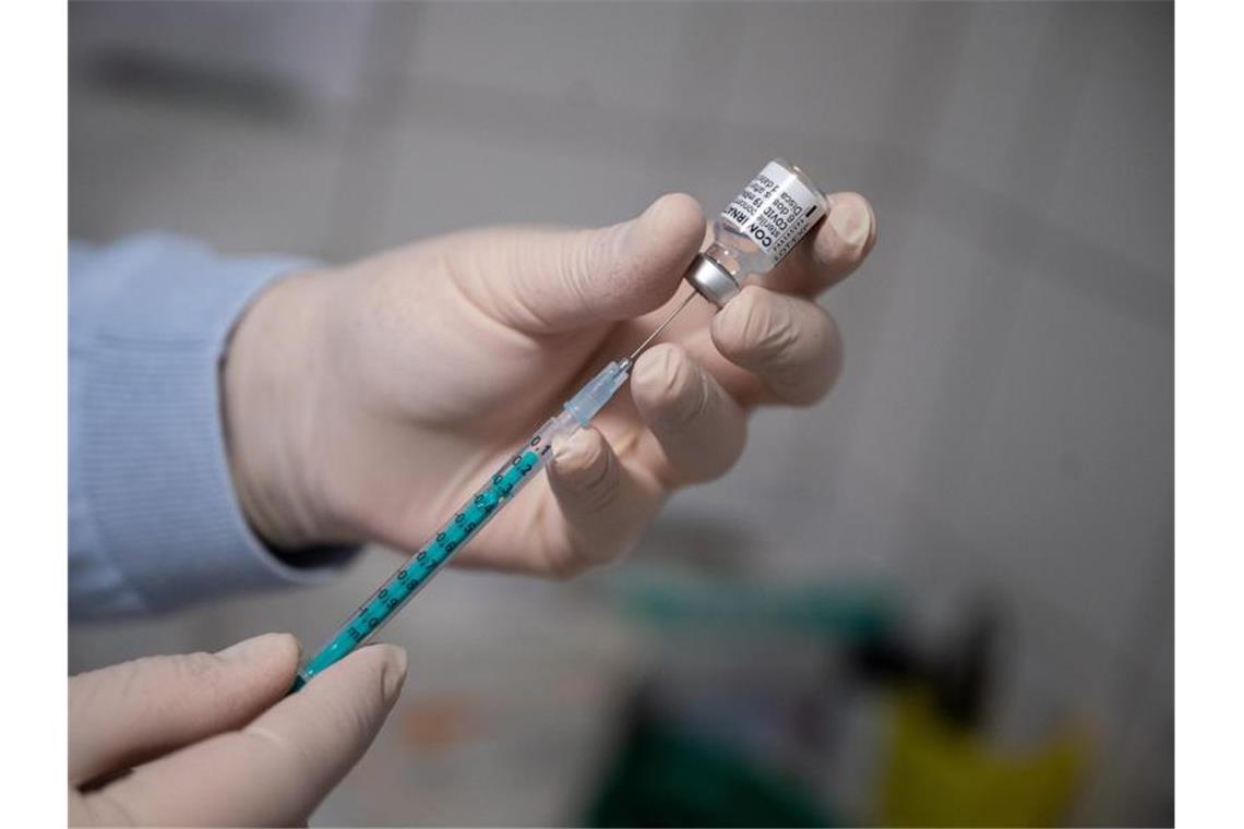Ein Arzt zieht in einer Hausarztpraxis eine Spritze mit dem Impfstoff von Pfizer/Biontech auf. Foto: Sebastian Gollnow/dpa