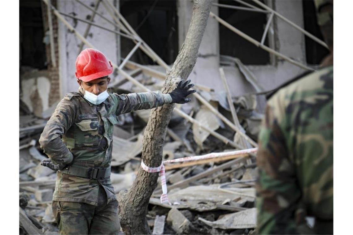 Berg-Karabach: Neue Feuerpause nach wenigen Stunden brüchig Ein aserbaidschanischer Soldat steht in der Nähe eines zerstörten Hauses in einem Wohngebiet, das von armenischen Streitkräften durch Raketenbeschuss getroffen wurde. Foto: Aziz Karimov/AP/dpa