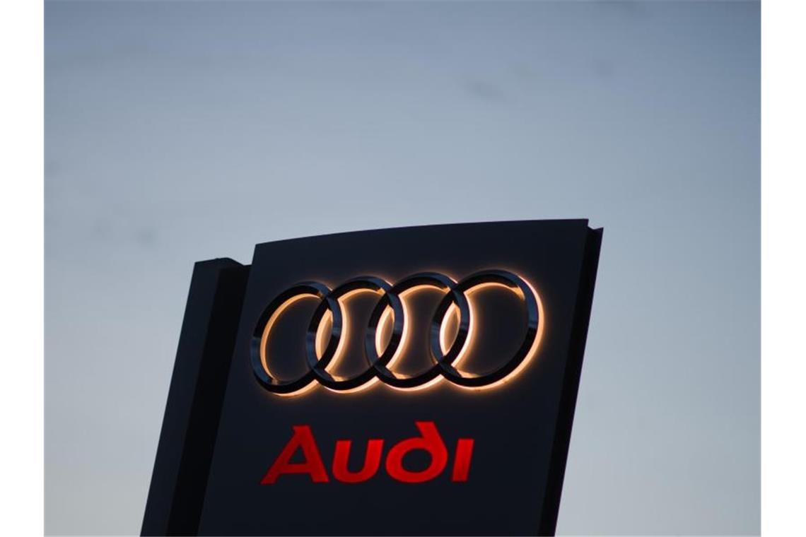 Ein Audi-Logo leuchtet in der Morgendämmerung an einem Autohaus. Foto: picture alliance / Julian Stratenschulte/dpa/Symbolbild