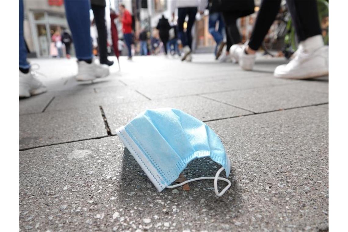 Bund und Länder vereinbaren schärfere Corona-Hotspot-Regeln Ein auf dem Boden liegender Mund-Nasen-Schutz in der Kölner Innenstadt. Der Bund will eine ergänzende Maskenpflicht einführen. Foto: Weronika Peneshko/dpa