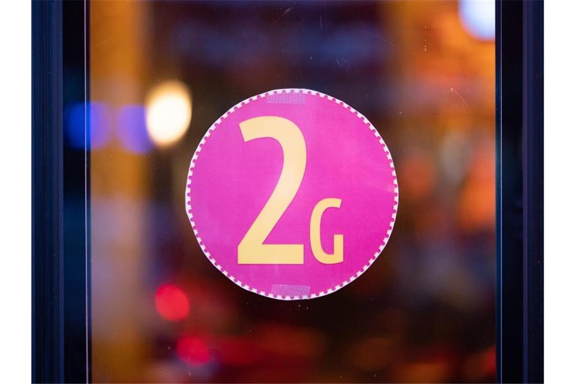 2G-Regel für Ungeimpfte tritt am Mittwoch in Kraft Ein Aufkleber an einer Glastür weist auf die 2G-Regel hin. Foto: Daniel Reinhardt/dpa/Symbolbild