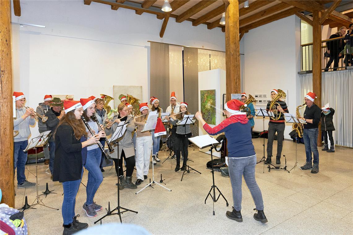 Gesang und Musik zwischen Kunst und Punsch: Weihnachtsmärkte rund um Backnang Ein Auftritt des Musikvereins Oberbrüden zwischen Kunstobjekten von Britta M. Ischka.