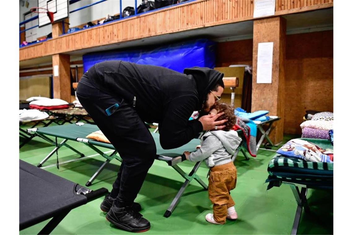 Immer mehr Menschen fliehen aus der Ukraine Ein aus der Ukraine geflüchteter Vater kümmert sich in einer ungarischen Notunterkunft um seine Tochter. Foto: Marton Monus/dpa