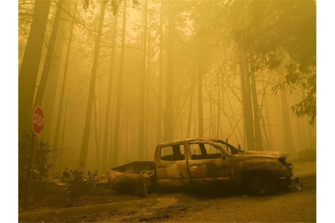 Ein ausgebranntes Fahrzeug steht am Straßenrand in Boulder Creek. Foto: Marcio Jose Sanchez/AP/dpa