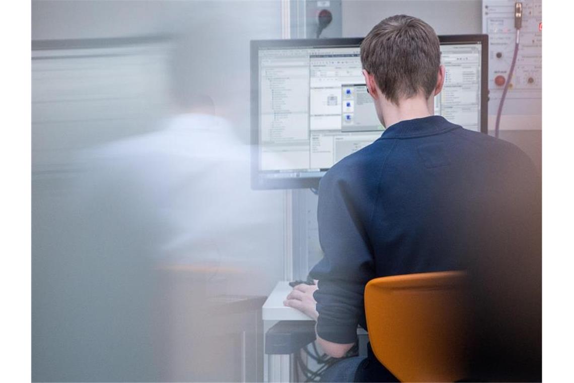 Ein Auszubildender der Mechatronik programmiert an einem Computer. Foto: Sebastian Gollnow/dpa