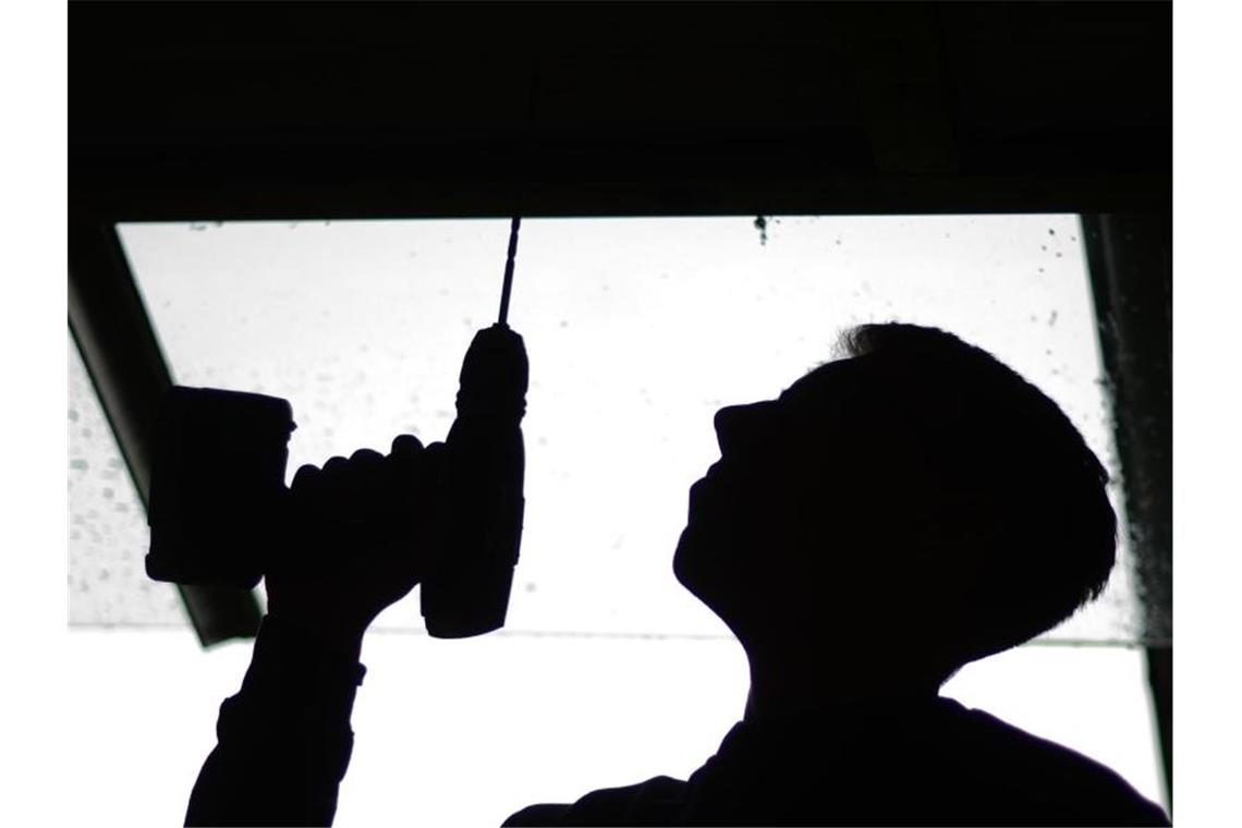 Corona verunsichert Jugend mit Blick auf Ausbildungschancen Ein Auszubildender im Tischlerhandwerk bohrt ein Loch in ein Brett. Foto: Julian Stratenschulte/dpa