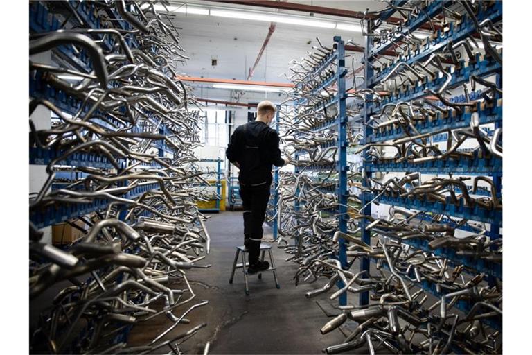 Ein Auszubildender steht im Lager in einer Fertigungshalle von Continental in Hamburg. Foto: Christian Charisius/dpa