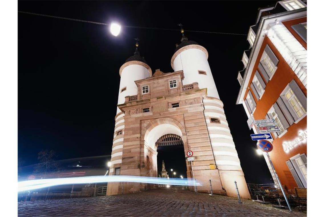 Altstadt-Gelage: Heidelberg führt Alkoholverkaufsverbot ein Ein Auto fährt am Brückentor an der Alten Brücke vorbei. Foto: Uwe Anspach/dpa/Archivbild