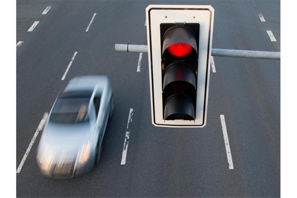 Ein Auto fährt an einer roten Ampel vorbei. Foto: Julian Stratenschulte/dpa