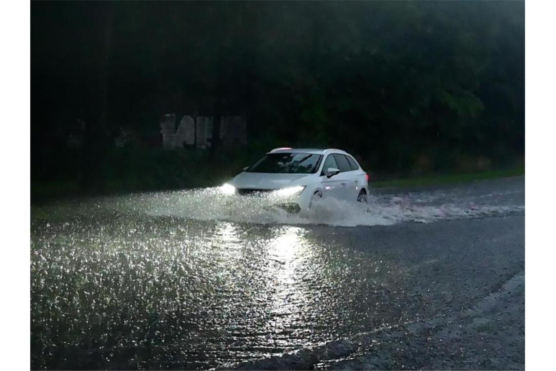 Warn-App vor Sturzfluten wird wohl im Herbst freigeschaltet Ein Auto fährt durch eine überflutete Straße. Foto: Alexander Forstreuter/Photography Alex Forstreuter/dpa/Symbolbild
