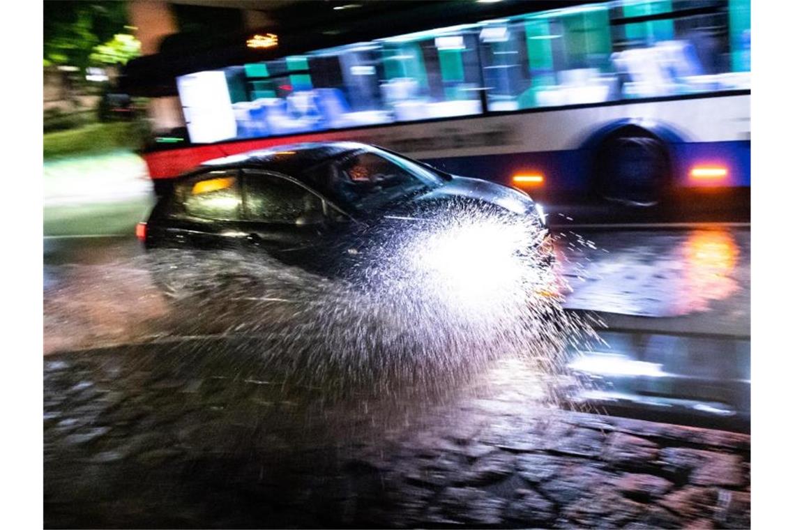 Ein Auto fährt durch eine Unterführung, die nach einem Gewitter mit Starkregenschauer überschwemmt ist. Foto: Matthias Balk/dpa/Archivbild