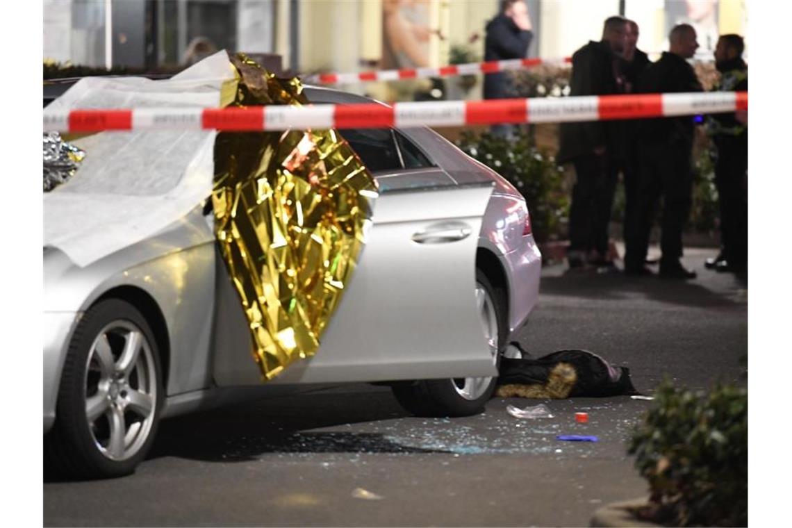 Ein Auto ist mit Thermofolie abgedeckt, neben dem Wagen liegen Glassplitter und eine Jacke. Foto: Boris Rössler/dpa