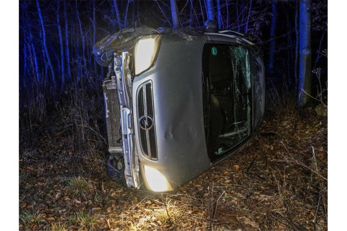 Ein Auto liegt nach einem Glatteisunfall in einem Wald auf der Fahrerseite. Foto: Kohls/SDMG/dpa/Archiv
