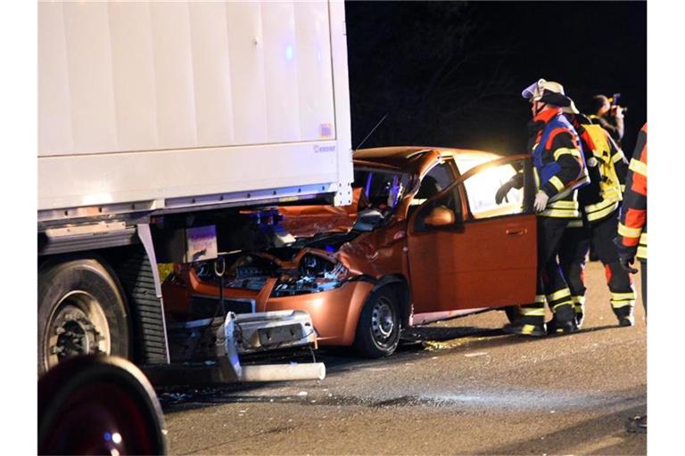 Ein Auto steht nach einem Unfall beschädigt am Heck eines Lastwagens. Foto: Marco Priebe/dpa