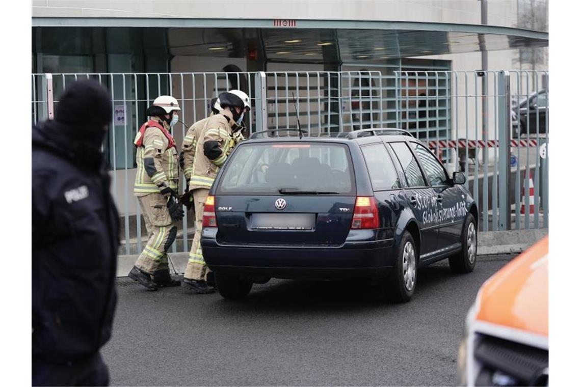 Ein Auto steht vor dem Tor des Bundeskanzleramts. Auf den Türen des Fahrzeugs stehen Beschimpfungen und politische Forderungen. Foto: Michael Kappeler/dpa