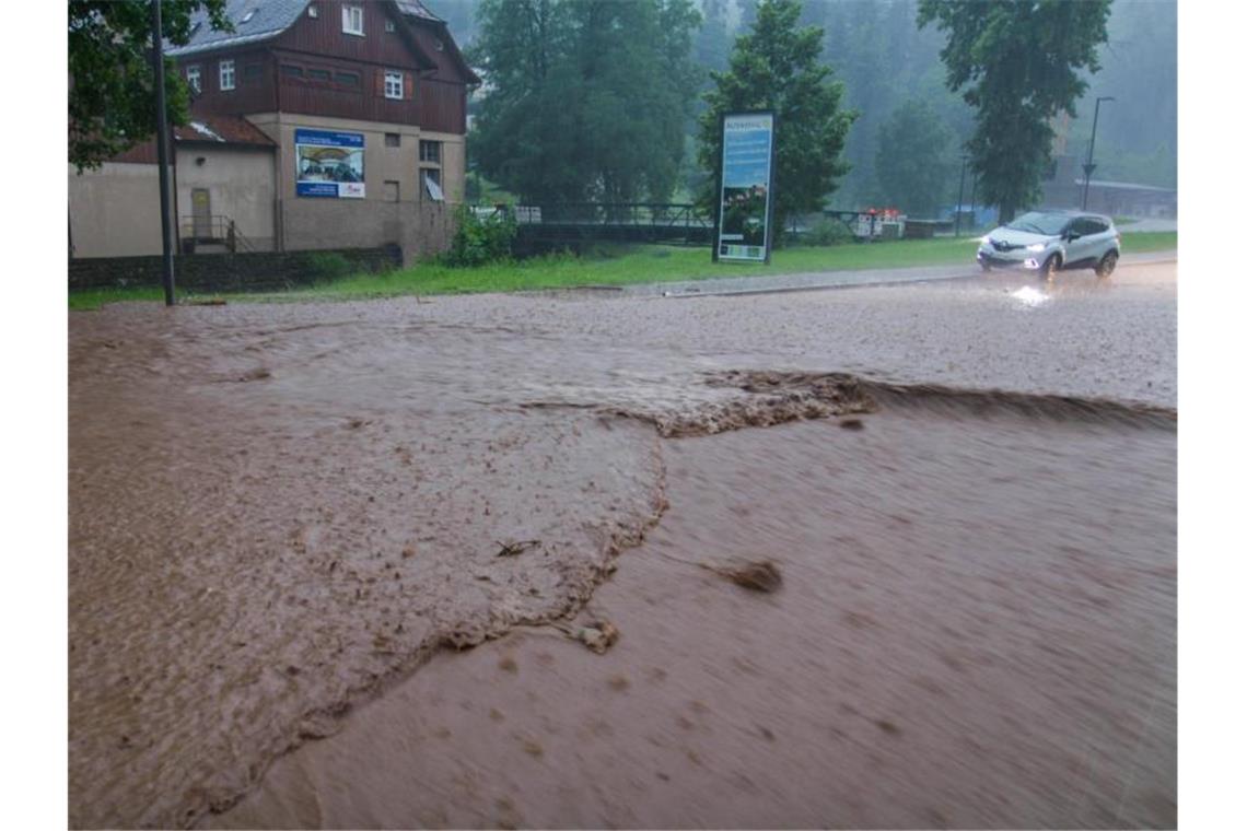 Heftige Unwetter in Bayern und Hessen Ein Auto steht während eines heftigen Unwetters auf einer überfluteten Straße in Altensteig im Landkreis Calw. Foto: Aaron Klewer/Einsatz-Report24/dpa