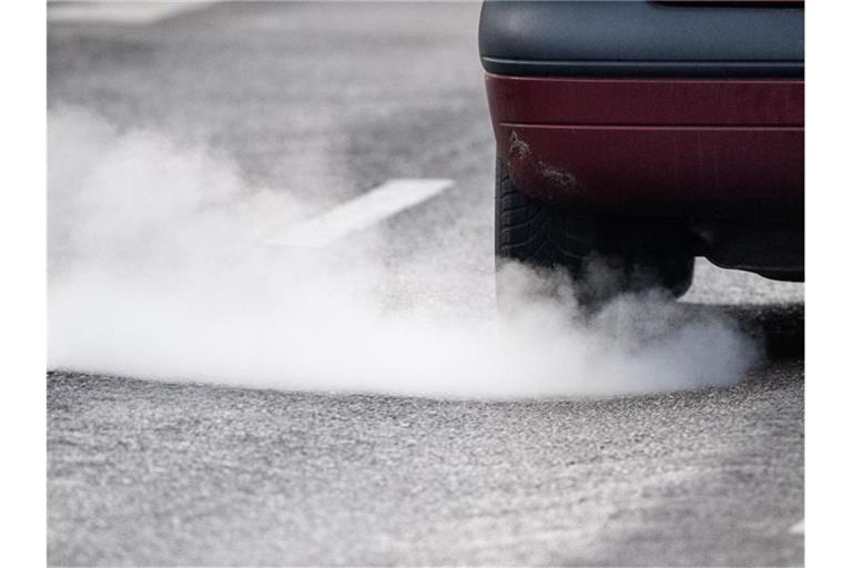 Ein Auto stößt während der Fahrt Abgase aus. Foto: Sebastian Gollnow/dpa/Archivbild