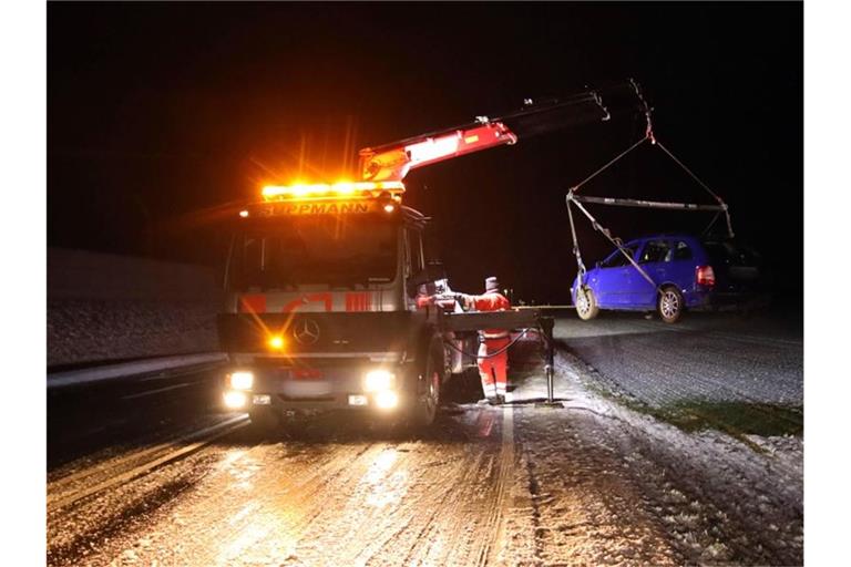 Ein Auto wird von einem Abschleppfahrzeug angehoben, nachdem es von der glatten Straße abkam. Foto: Alexander Auer/dpa