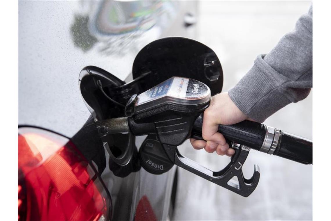 Ein Autofahrer steckt an einer Tankstelle einen Zapfhahn in die Tanköffnung seines Fahrzeugs. Für Kraftstoffe und Heizöl mussten Verbraucher zuletzt deutlich tiefer in die Tasche greifen als ein Jahr zuvor. Foto: Felix König/dpa