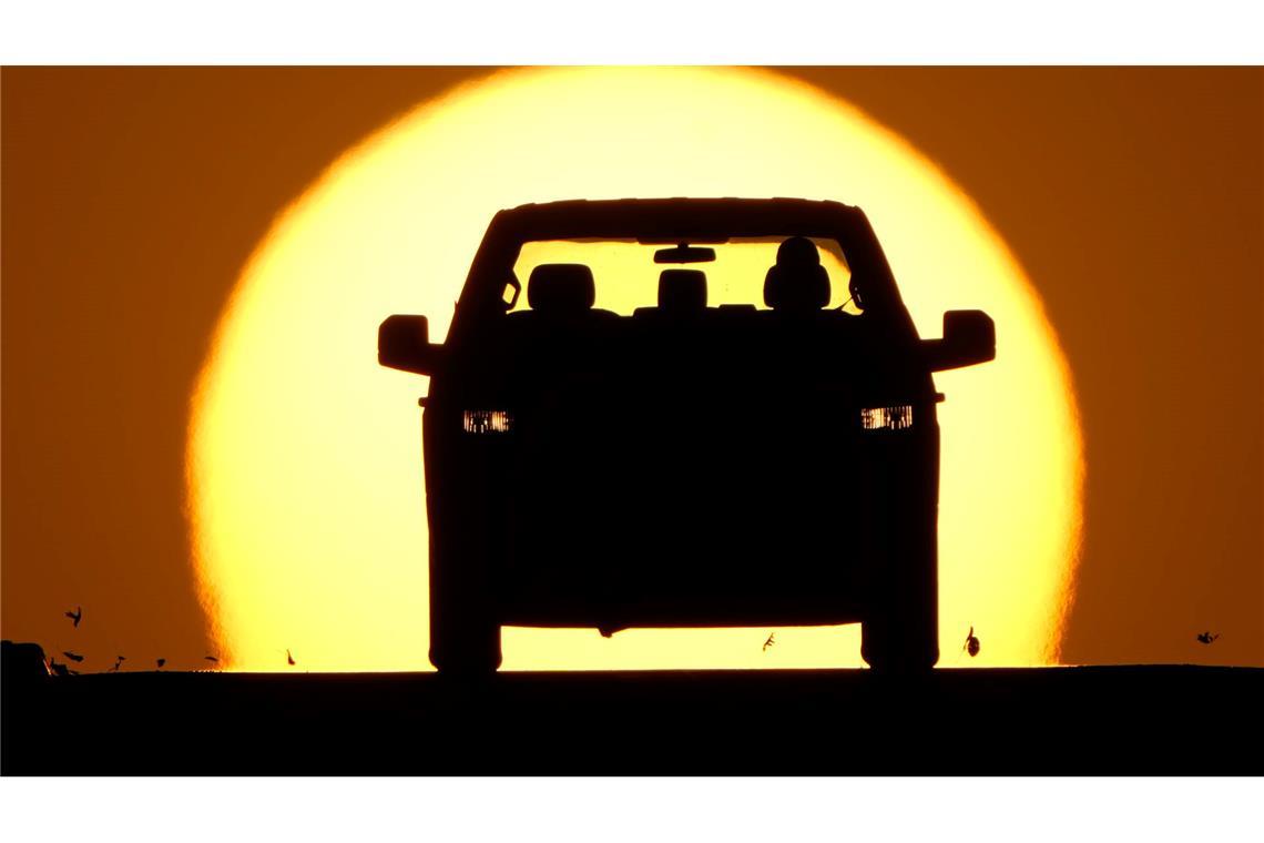 Ein Autofahrer wird von der untergehenden Sonne angestrahlt.