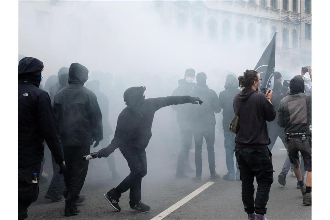 Brennende Barrikaden nach linker Demonstration in Leipzig Ein Autonomer wirft eine Flasche in Richtung des Gebäudes der Polizeidirektion Leipzig. Foto: Sebastian Willnow/dpa-Zentralbild/dpa