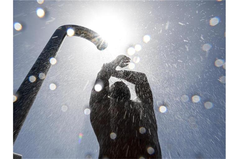 Ein Badegast duscht sich im Strand- und Freibad nach dem Baden im Bodensee. Foto: Felix Kästle