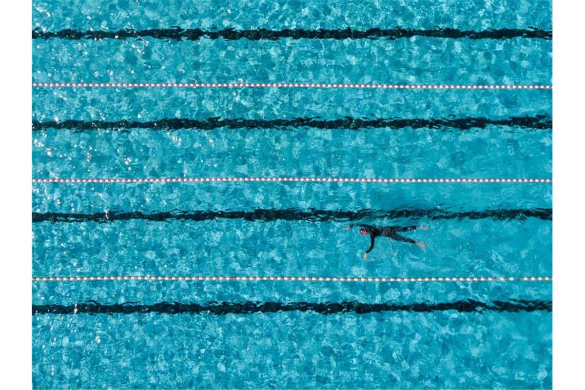 Ein Badegast schwimmt im Freibad in einem 50-Meter-Becken. Foto: Axel Heimken/dpa/Symbolbild