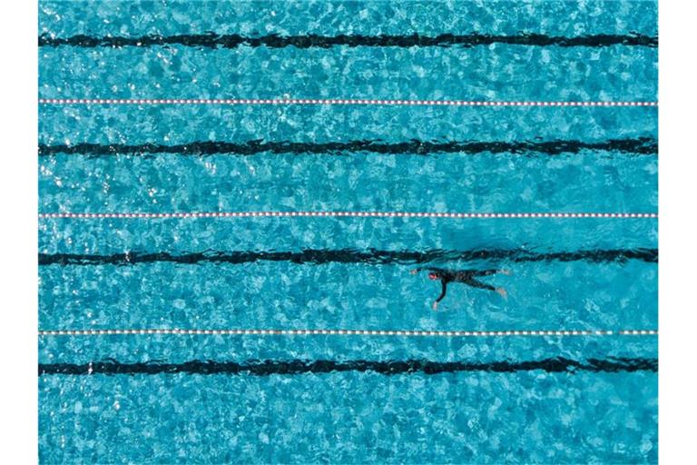 Ein Badegast schwimmt im Freibad in einem 50-Meter-Becken. Foto: Axel Heimken/dpa/Symbolbild