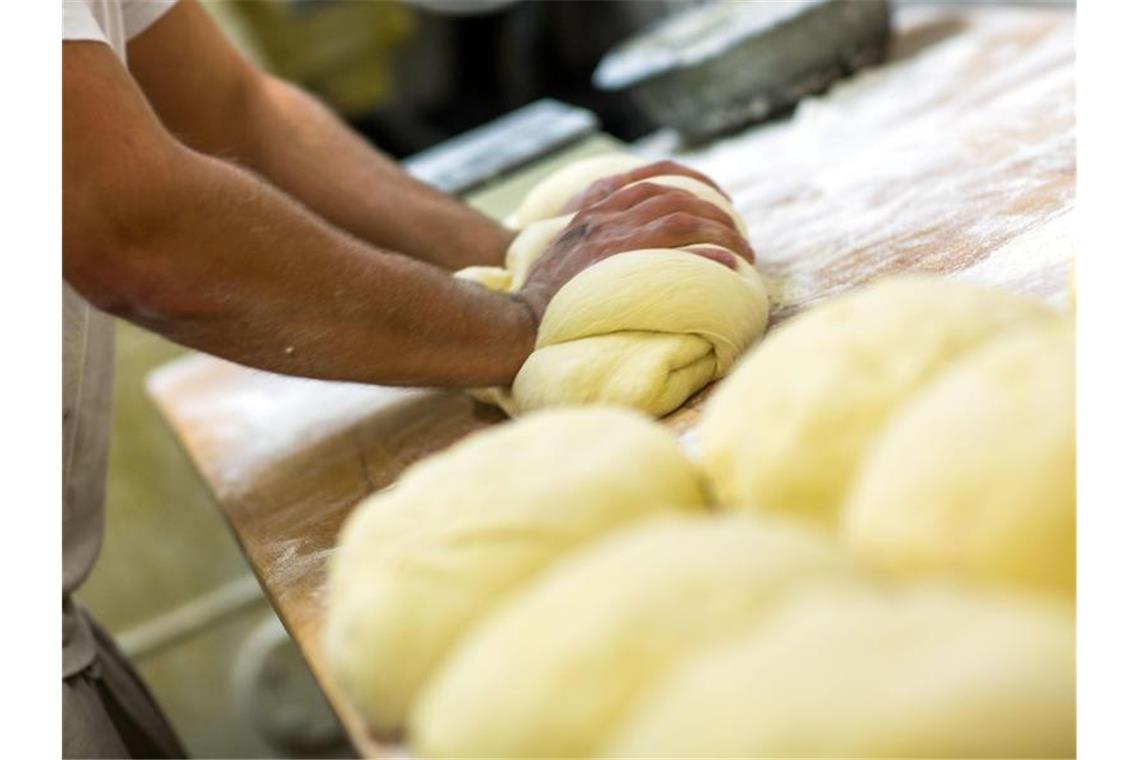 Ein Bäcker knetet in der Backstube einer Bäckerei Brotteig. Foto: Jens Büttner/dpa-Zentralbild/dpa/Archivbild