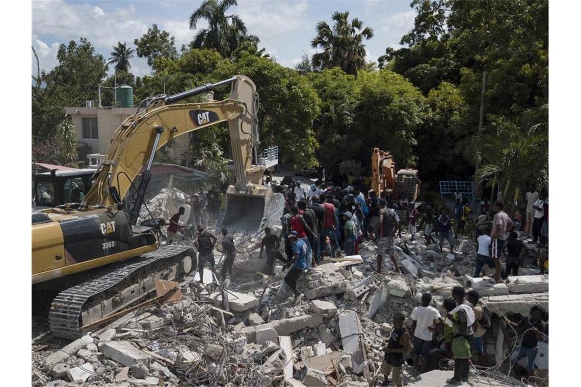 Ein Bagger entfernt die Trümmer eines eingestürzten Hotels. Foto: Matias Delacroix/AP/dpa