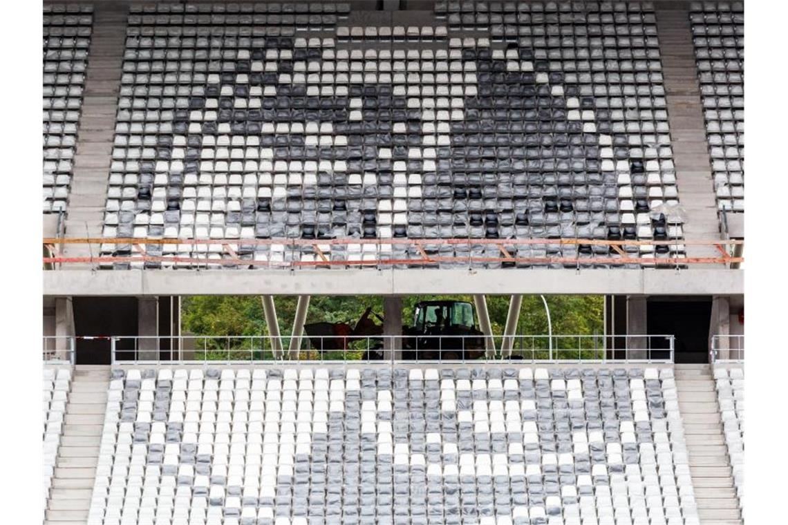 Freiburger Umzugstermin ins neue Stadion weiter offen Ein Bagger fährt hinter dem aus Sitzschalen gebauten Logo des SC Freiburg über die Baustelle. Foto: Philipp von Ditfurth/dpa/archivbild