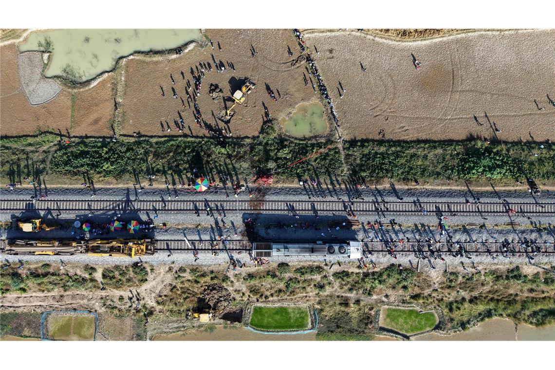 Ein Bagger hebt eine Grube aus, um den Kadaver eines Elefanten zu begraben, der bei der Kollision mit einem Zug ums Leben kam.