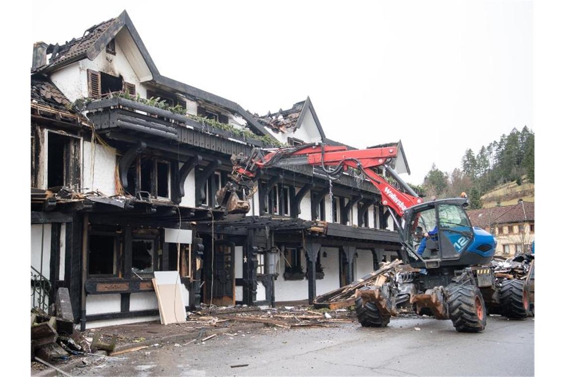 Ein Bagger räumt Schutt vor dem Eingang des ausgebrannten Restaurants weg. Foto: Sebastian Gollnow/dpa/Archivbild