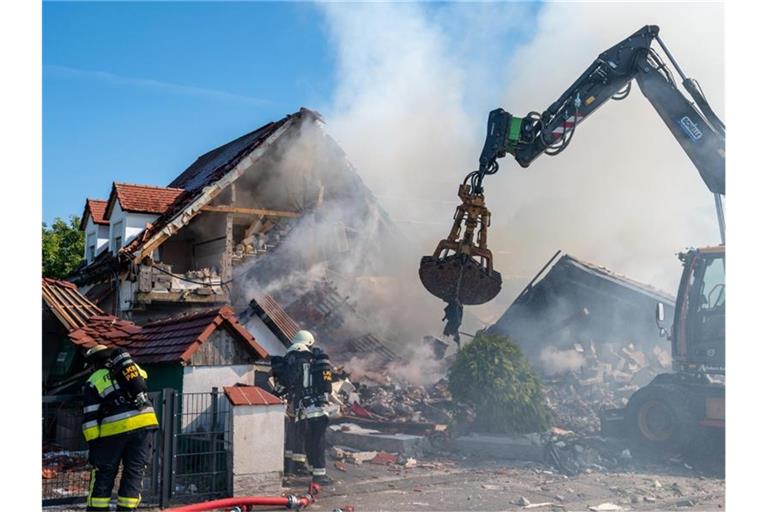 Ein Bagger räumt Teile des eingestürzten Hauses weg. Foto: Armin Weigel/dpa