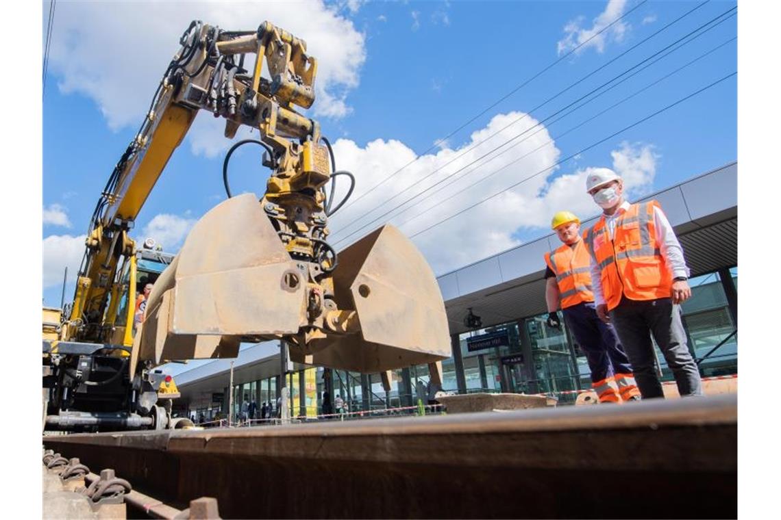 51 Bahnhöfe im Südwesten werden modernisiert Ein Bagger und Bauarbeiter stehen an einem Banhnhof. Foto: Julian Stratenschulte/dpa/Archivbild