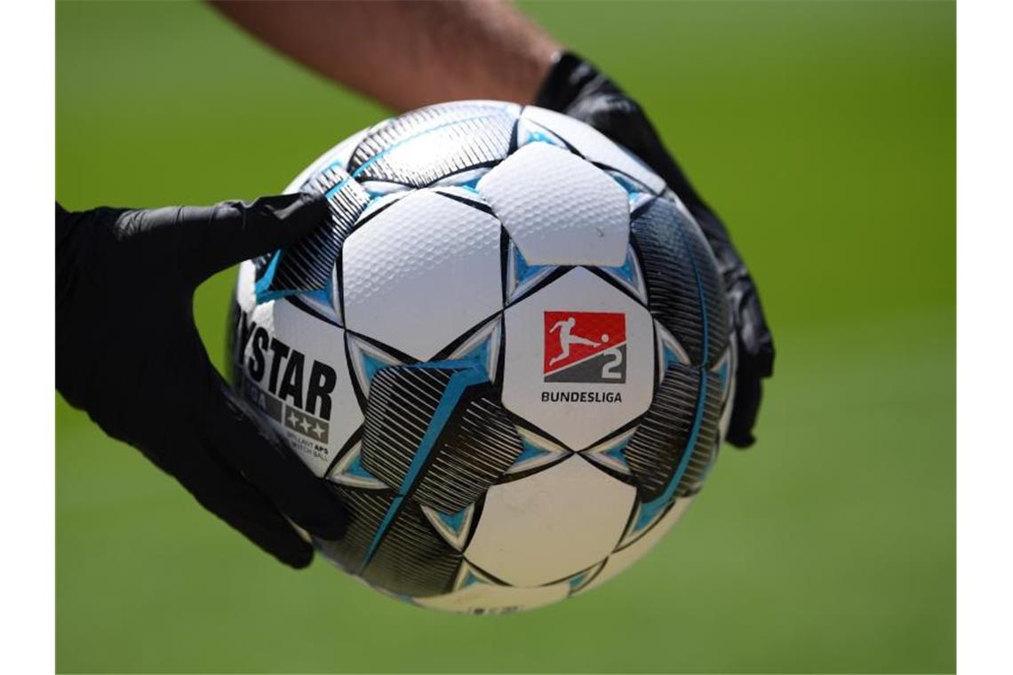 Ein Balljunge hält einen Spielball mit dem Logo der 2. Bundesliga. Foto: Matthias Hangst/Getty Images Europe/Pool/dpa/Symbolbild