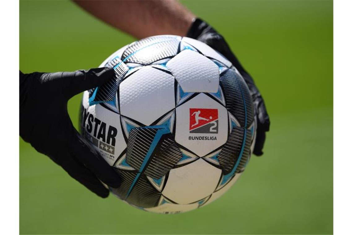 KSC-Straßenbahn übernachtet in Garage, VfB-Tross gar nicht Ein Balljunge hält einen Spielball mit dem Logo der 2. Bundesliga. Foto: Matthias Hangst/Getty Images Europe/Pool/dpa/Symbolbild