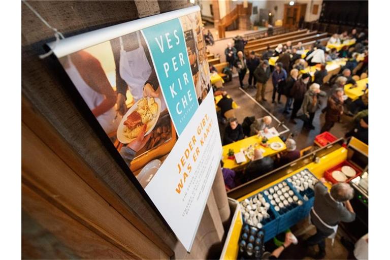 Ein Banner mit der Aufschrift „Vesperkirche“ hängt an einer Säule. Foto: Sebastian Gollnow/dpa/Archivbild