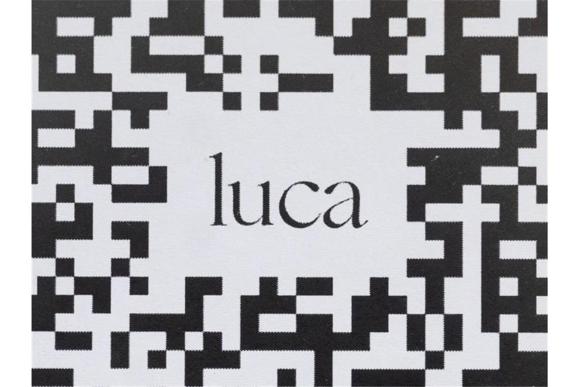 Weitere Fälle: Polizei wollte Daten der Luca-App haben Ein Barcode, der mit der Luca-App gescannt werden kann, hängt an einer Schutzscheibe. Foto: Marijan Murat/dpa/Symbolbild