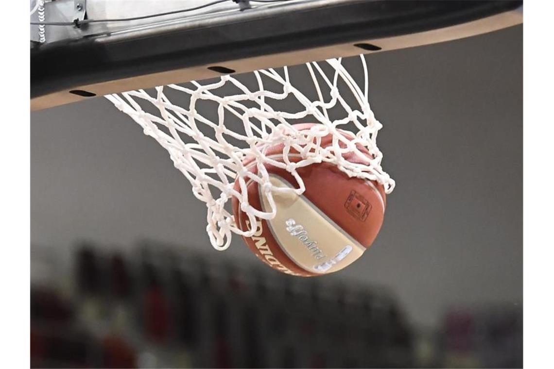 Ein Basketball landet im Korb. Foto: Thomas Kienzle/dpa/Symbolbild