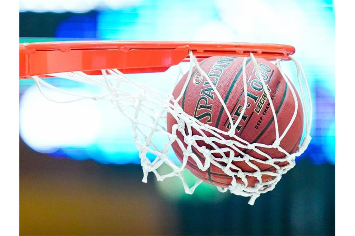 Ein Basketball landet im Korb. Foto: Uwe Anspach/dpa/Symbolbild